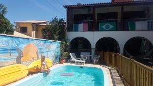 une femme est debout dans une piscine avec planches de surf dans l'établissement Geckos Hostel, à Florianópolis