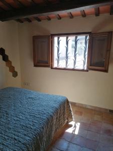 1 dormitorio con cama y ventana en Cal Niu, en Castillo de Aro