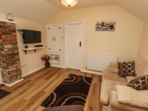 ein Wohnzimmer mit einem Sofa und einem TV in der Unterkunft Cherry Pips in Louth