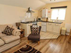 a living room with a couch and a kitchen at Cherry Pips in Louth