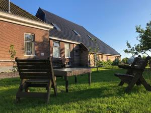 a table and chairs in the grass in front of a house at Onder De Boom in Gerkesklooster