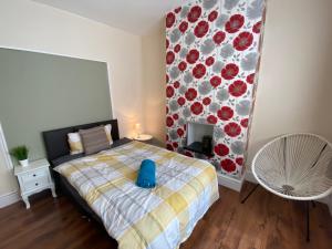 a bedroom with a bed with a blue pillow on it at Edinburgh Place in Kettering