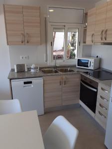a kitchen with a sink and a microwave at Apartamentos Dins Mar Apto. 3 in Torredembarra +12 photos