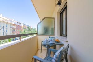 een balkon met een tafel en stoelen en een raam bij Del Parque Flats Candelaria Rincon in Rincón de la Victoria
