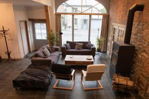a living room with couches and a brick wall at Maison Druyard huis met 5 slaapkamers in Durbuy