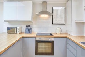 una cucina con armadi bianchi e piano cottura di Host & Stay - The Milton a Saltburn-by-the-Sea