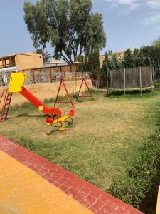 un parque infantil con un tobogán en un patio en Al Kasbah, en El Jadida