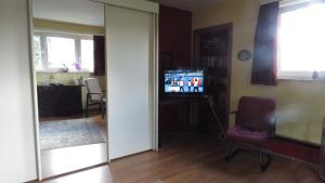a living room with a television and a chair at Prince d'Orange Bed & Breakfast in Braine-lʼAlleud