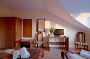 a bedroom with two beds and a desk with a television at Willa Klif &Spa in Jastrzębia Góra