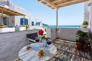 una mesa con copas de vino y vistas al océano en Ammos Sifnos Village, en Platis Yialos Sifnos