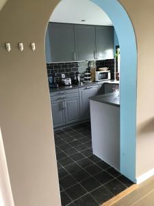 a kitchen with an archway in the middle of a room at Leuk vakantiewoning dijk woning met 3 slaapkamers dicht bij de Belgische grensen in Westdorpe