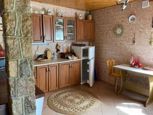 eine Küche mit Holzschränken und einem weißen Kühlschrank in der Unterkunft Domek na Kaszubach in Bieszkowice
