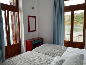 a bedroom with two beds and a window at Xenios Zeus Rooms in Koroni