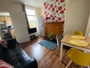 uma sala de estar com uma mesa e um sofá em Edinburgh Place em Kettering