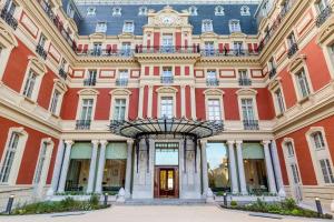 een gebouw met een klok erop bij Hôtel du Palais Biarritz, in The Unbound Collection by Hyatt in Biarritz