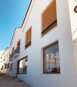 a white building with windows on the side of it at Apartamentos La Casa El Palo in El Rompido