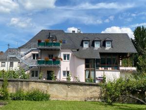 ein weißes Haus mit Balkonen an der Wand in der Unterkunft Katrin-Cara Mia Ferienwohnung in Trittenheim