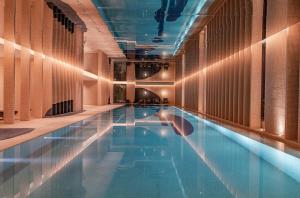 a swimming pool in a building with blue water at Mumian Beijing Daxing International Airport in Beijing