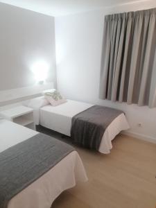 una camera d'albergo con due letti e una finestra di Apartamentos Horizonte a Playa del Ingles