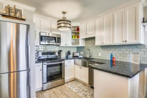 eine Küche mit weißen Schränken und einem Kühlschrank aus Edelstahl in der Unterkunft Seascape 2317 Condo in Galveston