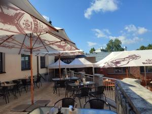 a patio with tables and chairs and umbrellas at Nábřežní terasy in Žďár nad Sázavou