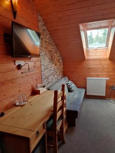 una habitación con una mesa y un sofá en una cabaña en Nábřežní terasy, en Žďár nad Sázavou