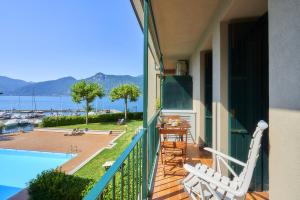 a balcony with two chairs and a table and a pool at Aria di Breva in Lierna