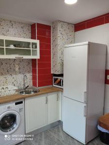 a kitchen with a white refrigerator and a washing machine at Casa La Maravilla in Jerez de la Frontera
