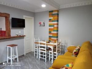 a living room with a yellow couch and a table at Casa La Maravilla in Jerez de la Frontera