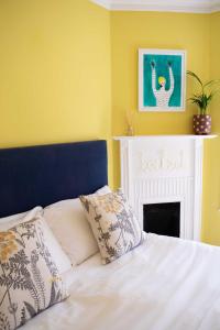 1 dormitorio con cama blanca y chimenea en The Falstaff Hotel & Restaurant Ramsgate, en Ramsgate