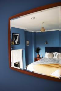 a mirror reflecting a bedroom with a bed and a fireplace at The Falstaff Hotel & Restaurant Ramsgate in Ramsgate