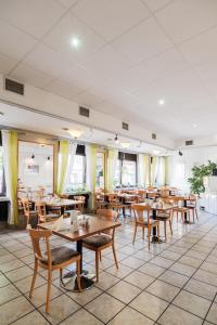 une salle à manger avec des tables et des chaises en bois dans l'établissement Hotel Pelikan, à Schwäbisch Gmünd