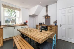 a kitchen with a wooden table and a counter top at 7 The Townhouse in Keswick