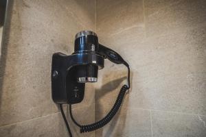 a phone hanging on a wall in a bathroom at Fontanella Green House in Barcelona