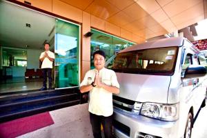 a man is standing in front of a van at C & N Hotel - SHA Extra Plus in Patong Beach