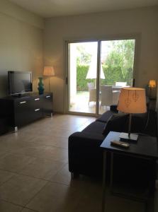 a living room with a couch and a television at Sunny Garden Limassol Star in Limassol