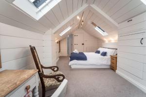 a bedroom with a bed in a attic with skylights at Barf Cottage in Portinscale