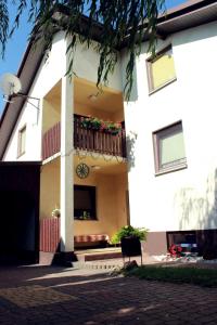 a white building with a balcony with flowers on it at Zielone Drzwi in Starachowice