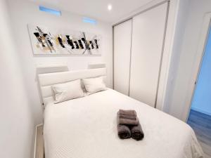 sypialnia z białym łóżkiem z pluszakiem w obiekcie Luxury Atlantico View w Puerto del Carmen