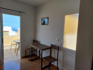 Zimmer mit einem Tisch, Stühlen und einem Fenster in der Unterkunft Apartamento Pequeña Perla in Tazacorte