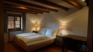um quarto com uma cama e uma secretária com 2 candeeiros em Bauernhaus am Pfänderhang mit Seeblick em Lochau
