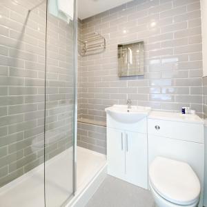 a bathroom with a toilet and a sink and a shower at South Sands Hotel in Weston-super-Mare