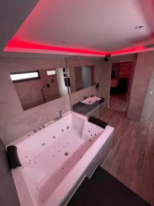 a large white bath tub in a room with red lighting at Apartamentos Las 7 Esencias in Linares