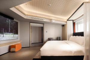 a bedroom with a large white bed and a window at Arthur Hotel Canton Tower Guangzhou-广州塔骑士物语酒店 in Guangzhou