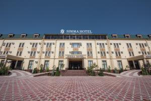 a large tan building with a sign on it at Simma Hotel Spa & Waterpark in Tashkent