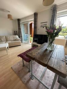 a living room with a wooden table with flowers on it at Pass the Keys Lovely 2Bedroom flat with balcony in Edinburgh