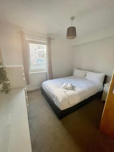 a bedroom with a bed with a towel on it at Pass the Keys Lovely 2Bedroom flat with balcony in Edinburgh
