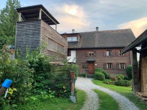 uma casa com um caminho que leva ao jardim da frente em Bauernhaus am Pfänderhang mit Seeblick em Lochau