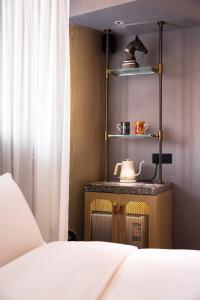 a bedroom with a bed and a shelf with a tea kettle at Arthur Hotel Canton Tower Guangzhou-广州塔骑士物语酒店 in Guangzhou