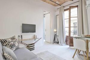 a white living room with a couch and a television at Apartamento Alejandro en BCN in Barcelona
